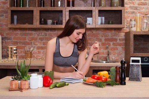 A woman writing on a kitchen table.
