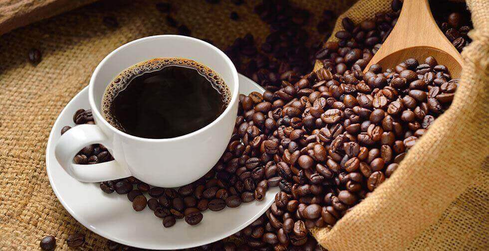 Übermäßiger Kaffeekonsum - Tasse Kaffee und Kaffeebohnen