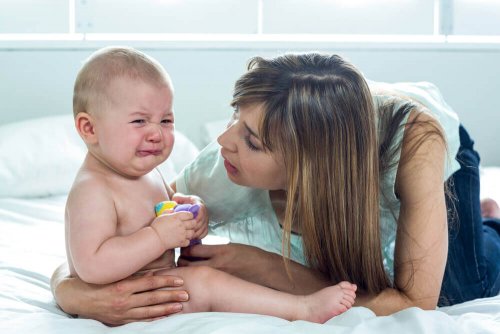 A baby crying with his mother.