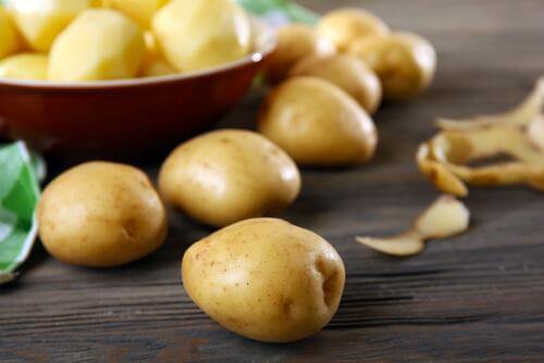 Peeled and unpeeled potatoes.