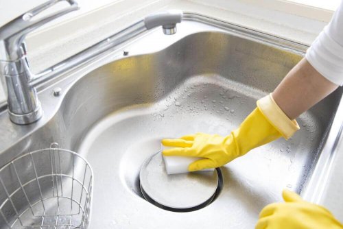 A woman cleaning her sink.