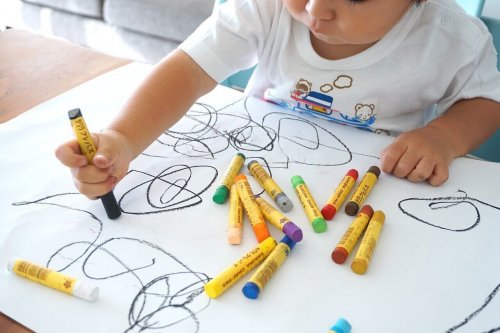 A child drawing with crayons.