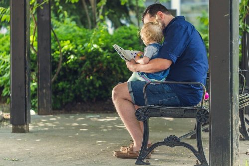 A man and a baby looking at a book.