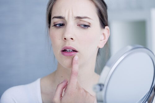 A woman pointing at her mouth.