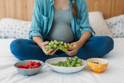 Safe medications: A woman sitting on a bed with three bowls of fruit in front of her.