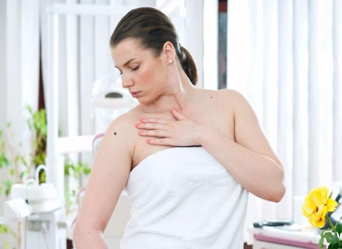 A lady examining her back.