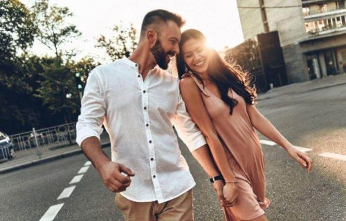 A couple smiling and holding hands.