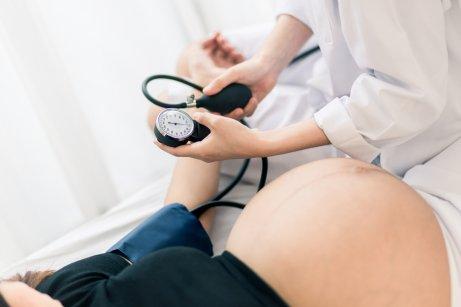 A pregnant woman getting her blood pressure checked.
