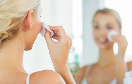 A woman cleaning her skin.