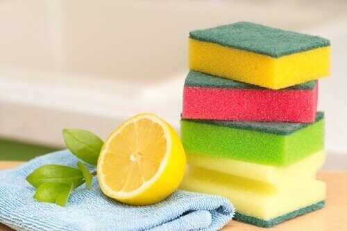 A display of sponges, rags and half a lemon.