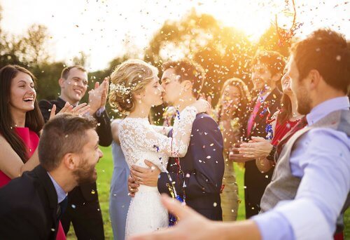 A wedded couple kissing.