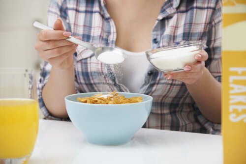 A woman dumping sugar on her cereal.