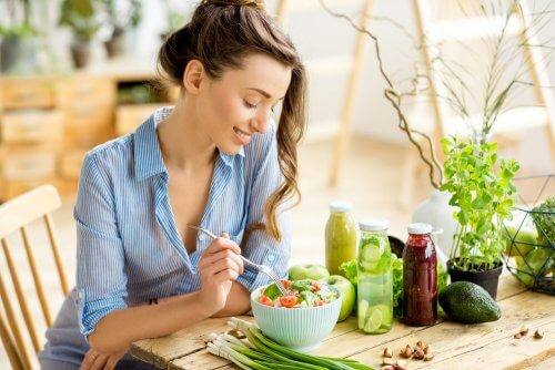 A seated woman eating a salad.
