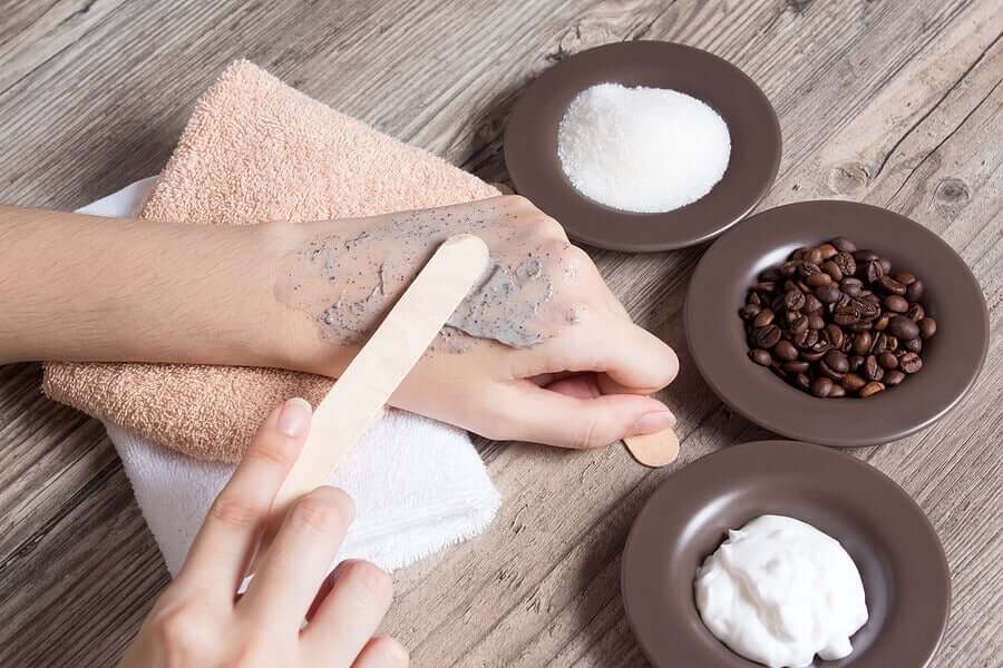 A woman applying a coffee sugar scrub to her hands.