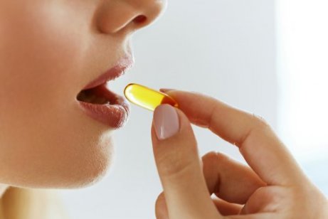A woman taking a vitamin K supplement.