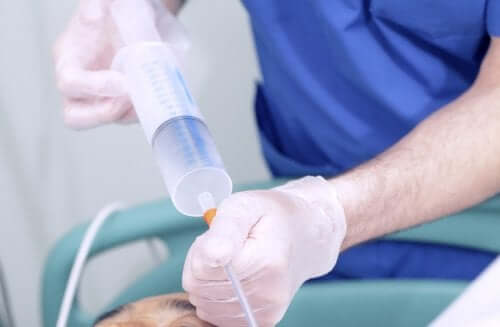 A doctor injecting liquid in a feeding tube.