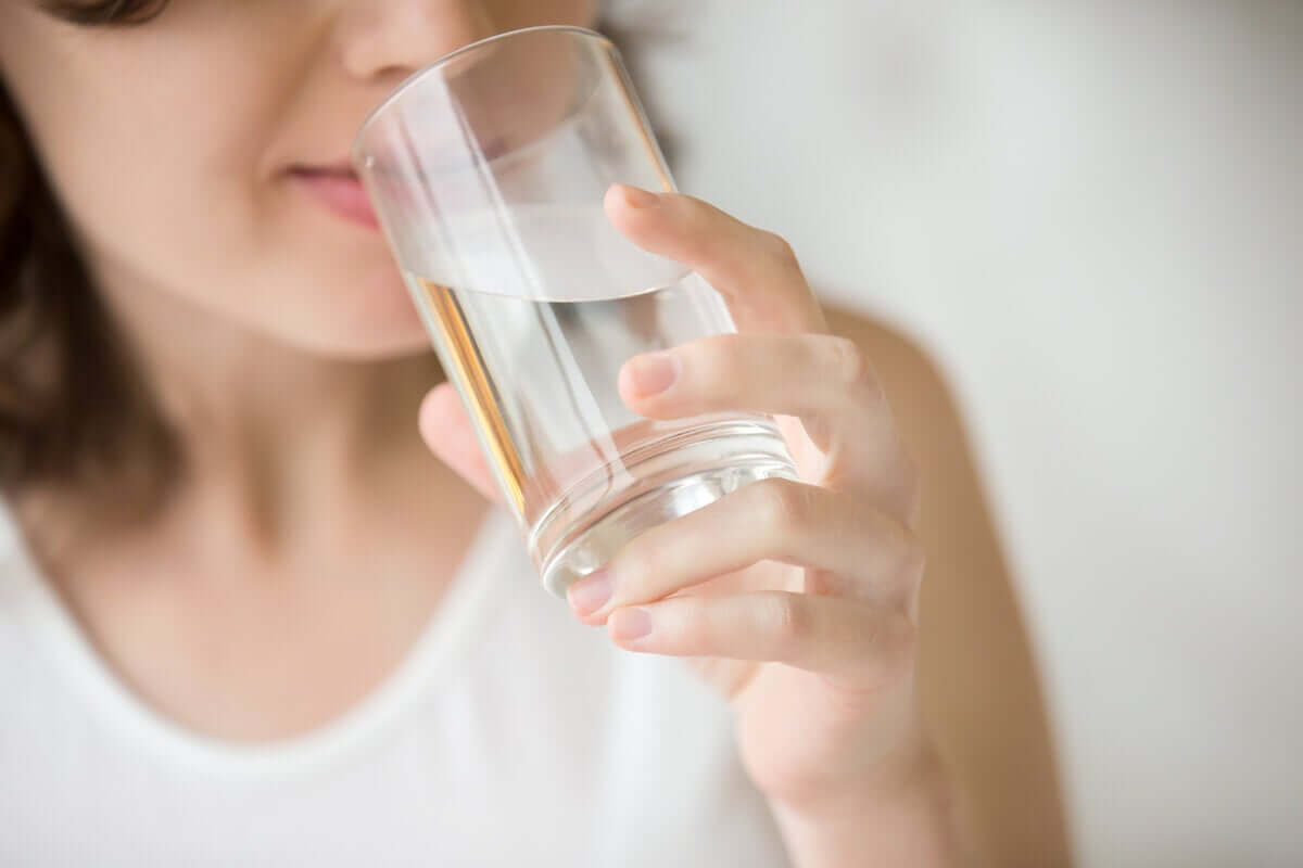 A woman drinking a glass of water.