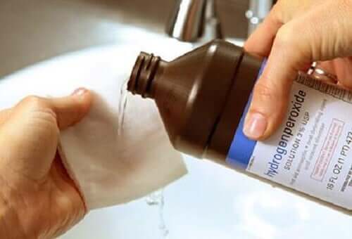 A person pouring hydrogen peroxide on a gauze.