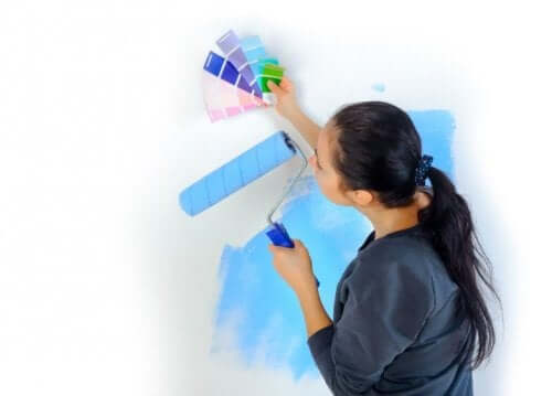A woman choosing a paint color for a wall.