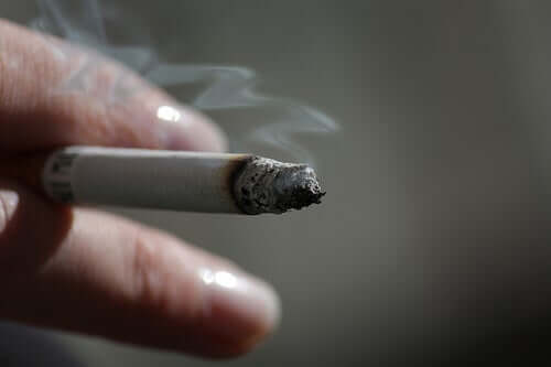 A hand holding a cigarette.