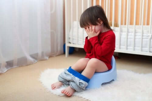 A sleepy child seated on the potty