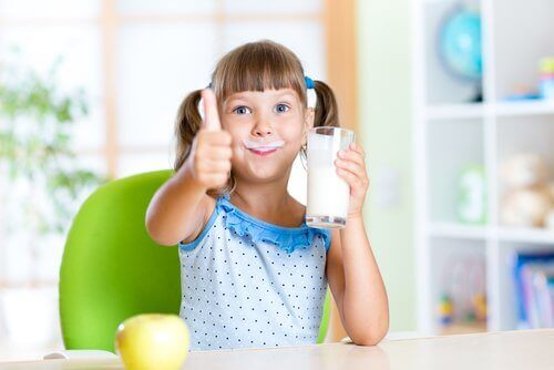 A girl drinking a glass of milk.