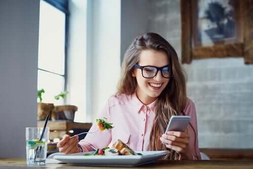 A woman eating with distractions.