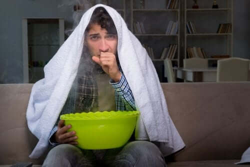 A man with a towel on his head holding a bowl.