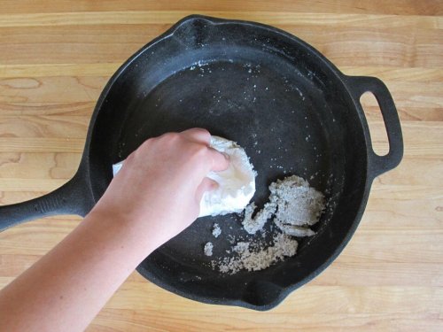 A person scrubbing a pan.