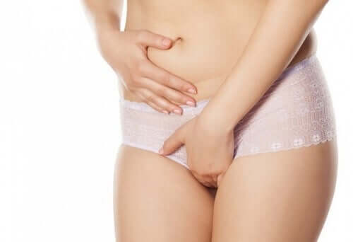 A woman holding her genital area.
