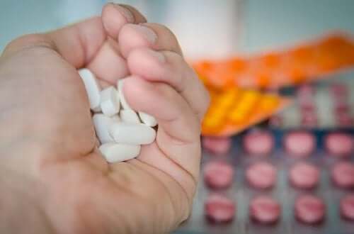 A hand holding pills.