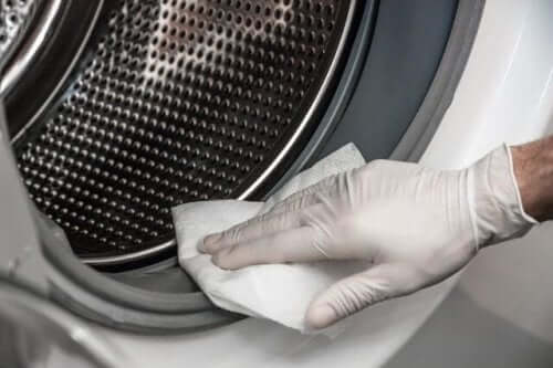A person cleaning their washing machine.