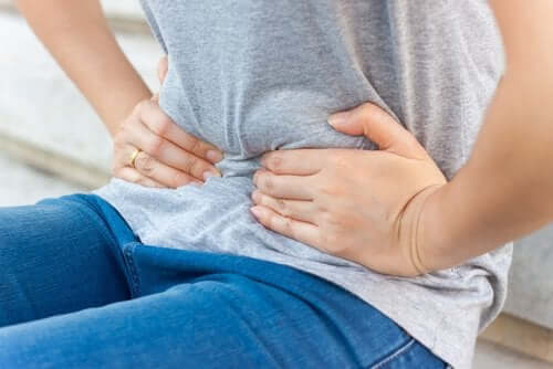 A woman pressing on her belly.