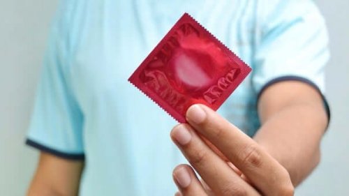 A man holding a condom.