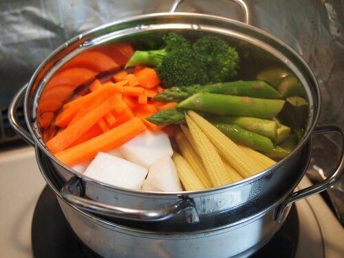 Some vegetables boiling in a pot.