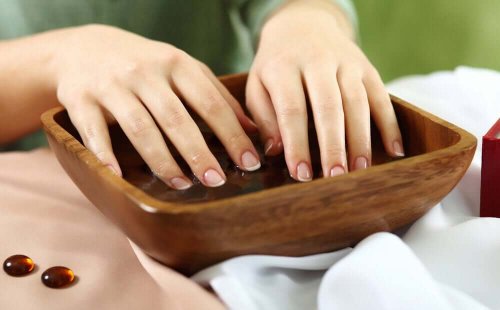 A woman soaking her nails in garlic water.