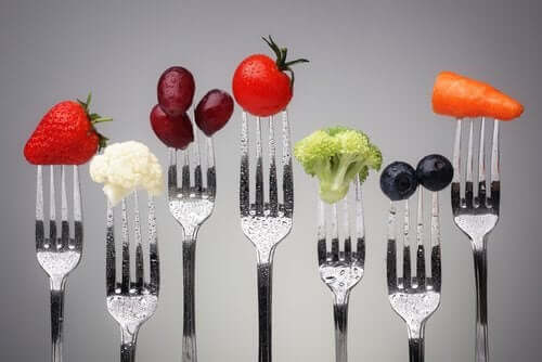 A set of forks with various types of food.