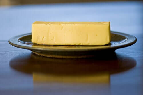A stick of butter on a plate.