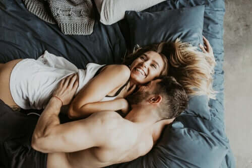 A couple kissing in bed.