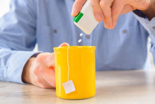Man pouring artificial sweetener into tea diet soda.
