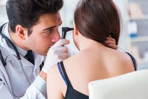 A doctor checking a woman's ear.