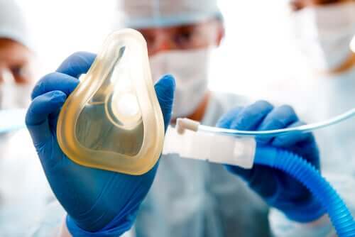 A medical professional holding a simple face mask.