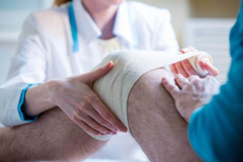 Doctors dressing a knee with a bandage.