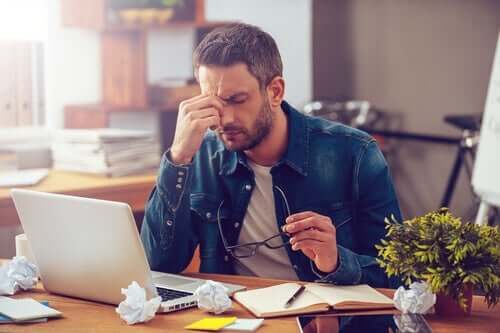 The post-vacation blues man at desk stressed.