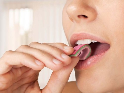 A woman putting gum in her mouth.