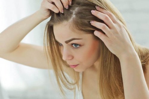 A woman looking at her hair roots.
