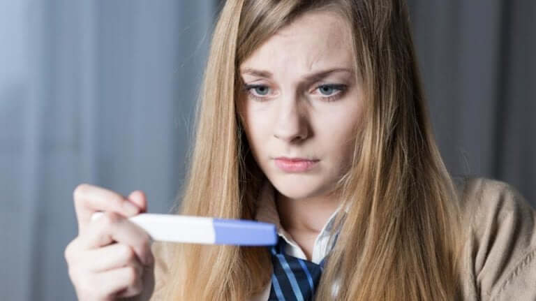 Concerned woman holding a pregnancy test.