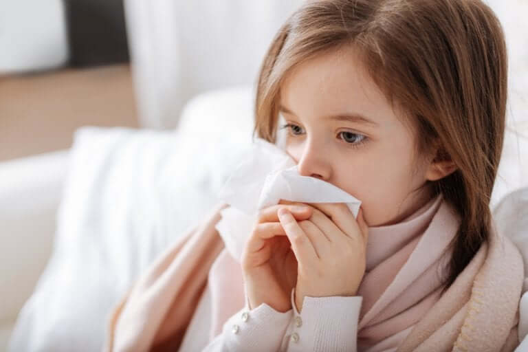 Girl blowing her nose on the couch.