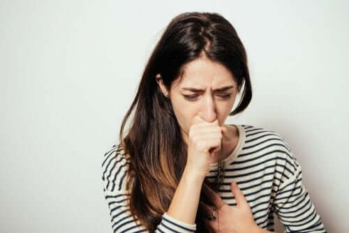 Woman in a striped shirt coughing.