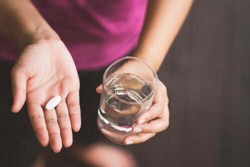 Kvinna tar paracetamol med vatten